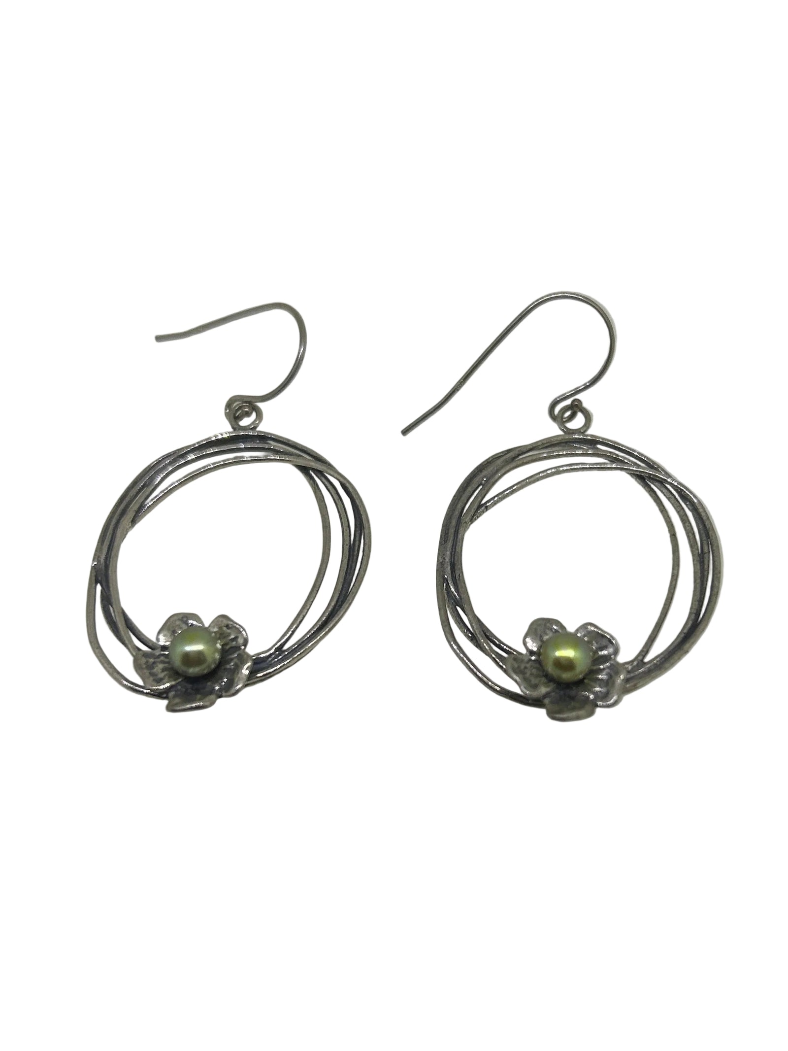 A pair of silver-toned dangle earrings with nested circular wire designs and a small green bead accent, displayed on a white surface.