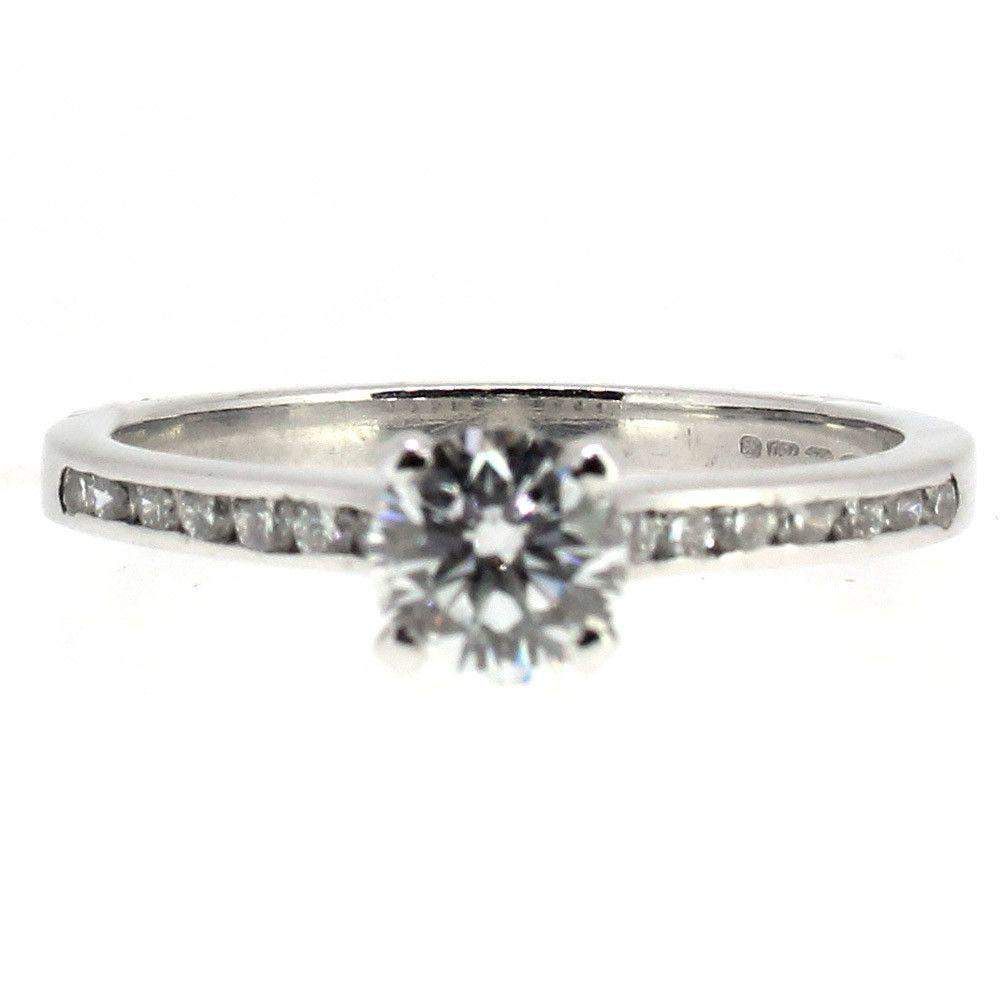 Silver engagement ring with round diamond and side stones on a white background