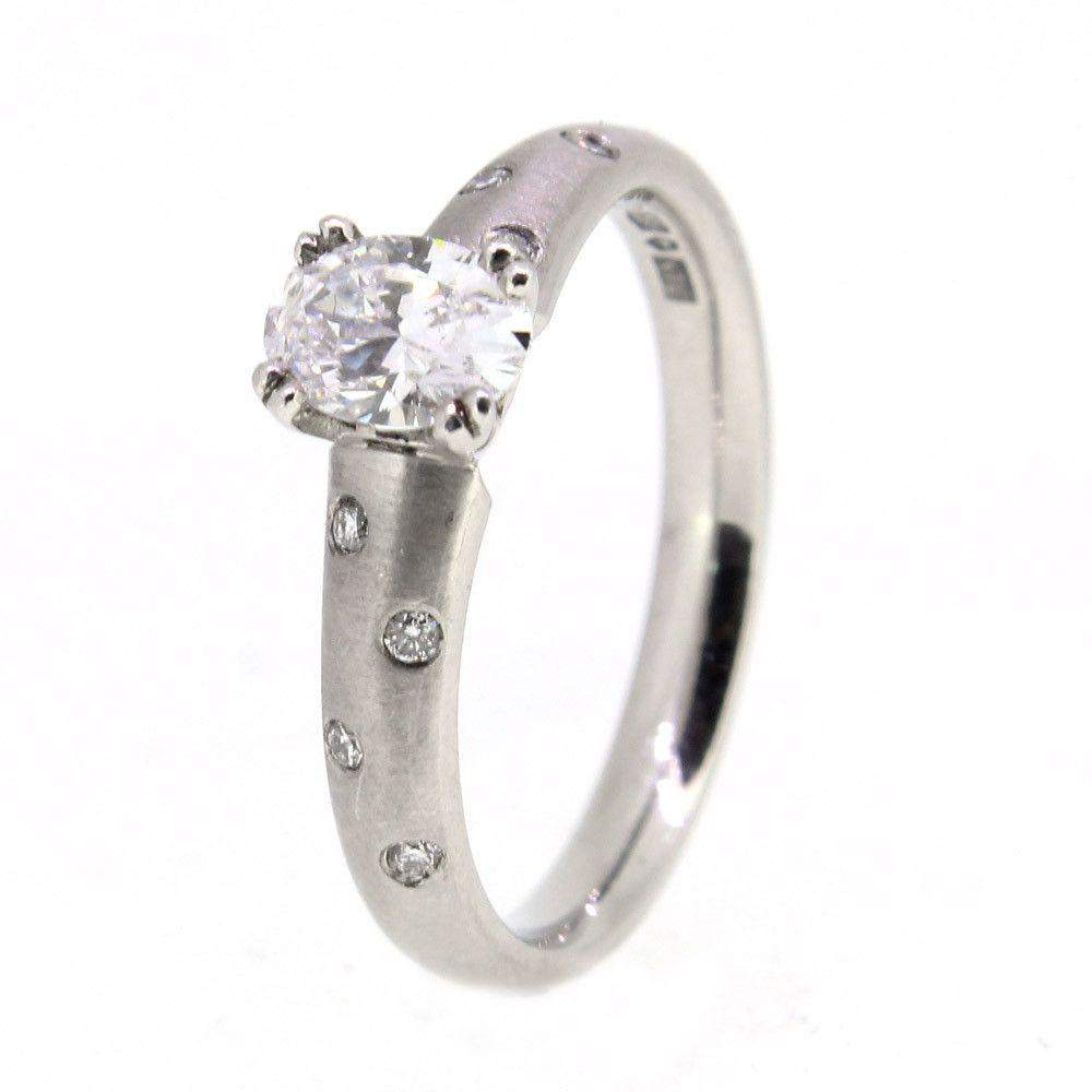 Closeup of a silver engagement ring with a round diamond center