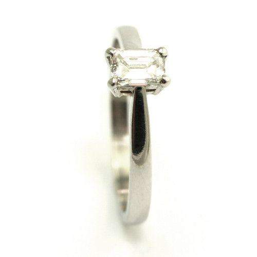 Silver ring with an emeraldcut diamond in a prong setting elegant design